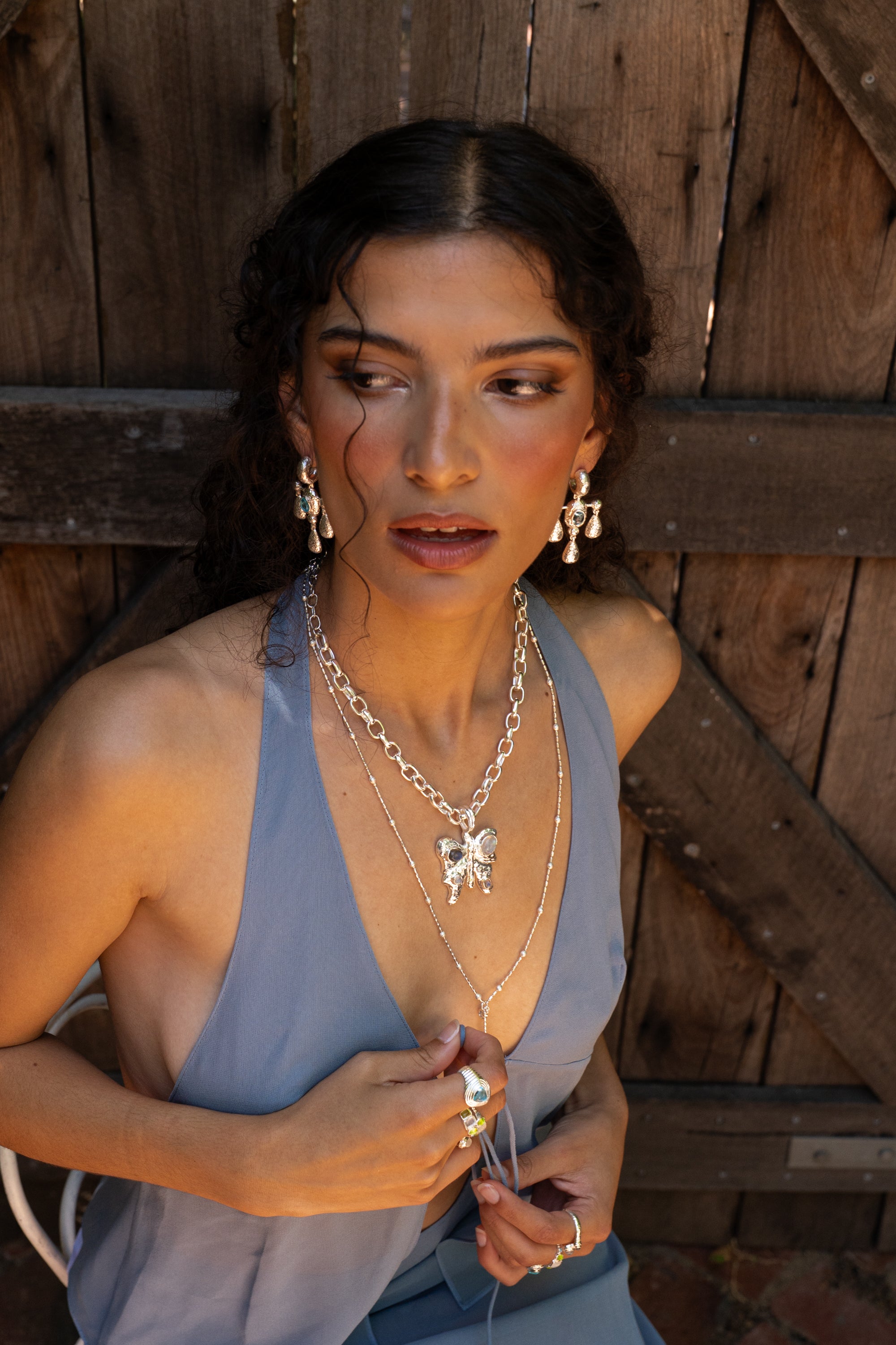 Fleur chandelier drop earrings styled on model, Glass Blue Topaz in silver — Mountain & Moon jewellery