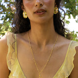 Darcy gold hammered oval stud earrings with Freshwater Pearl and Glass Blue Topaz worn by model — Mountain & Moon Chateau Soleil collection